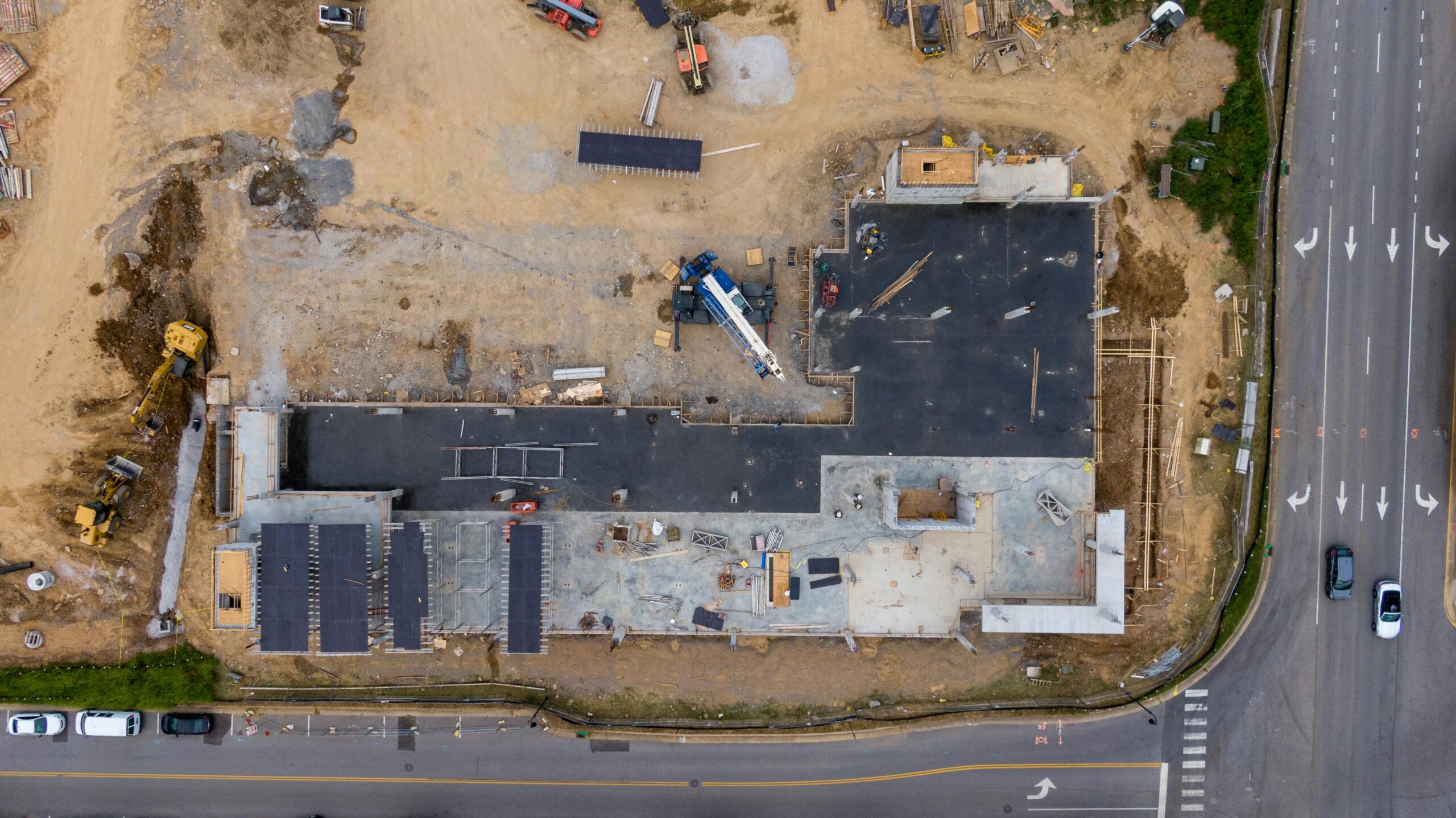 Home Aerial view of an active construction site with machinery and vehicles.