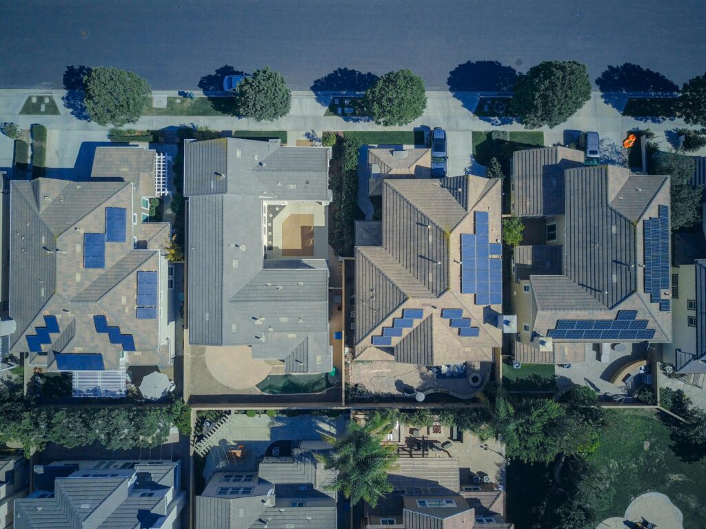 Home Top-down view of urban houses with solar panels emphasizing clean energy solutions.