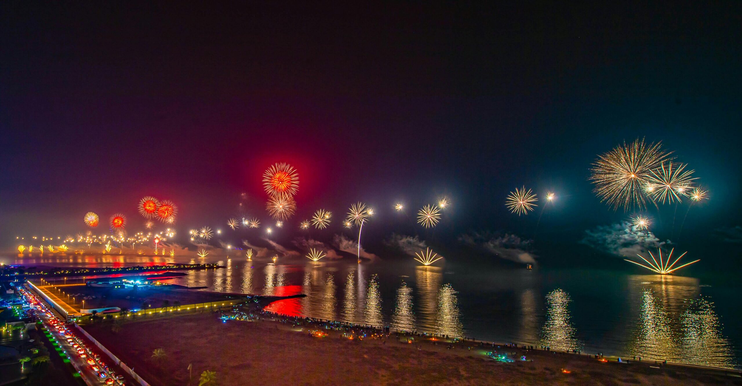 Services Dazzling fireworks light up the night sky over Ras Al Khaimah, reflecting vividly on the water.